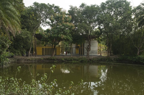54e67d8ee58ece33a800004c_pani-community-centre-schilderscholte-architects_pani_community_centre_bangladesh_west_facade_view_with_pond_schildersc